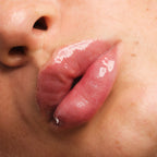 Close-up of glossy sheer pink lips with fine shimmer wearing Jelly Gloss