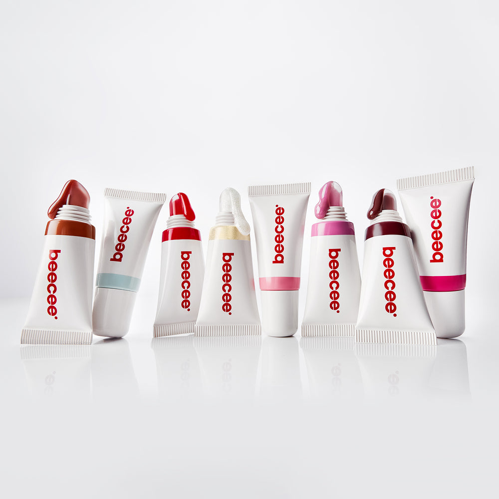 Eight Jelly Gloss squeeze tubes in different shades lined up on a white surface