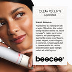 A close-up of a woman holding a white Beecee Superfine Mist spray bottle next to a white informational card explaining the fragrance-free formula, on a black background.