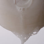 Video of the well rounded soap bar bubbling and dripping suds against a white background. 