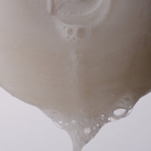 Video of the well rounded soap bar bubbling and dripping suds against a white background. 