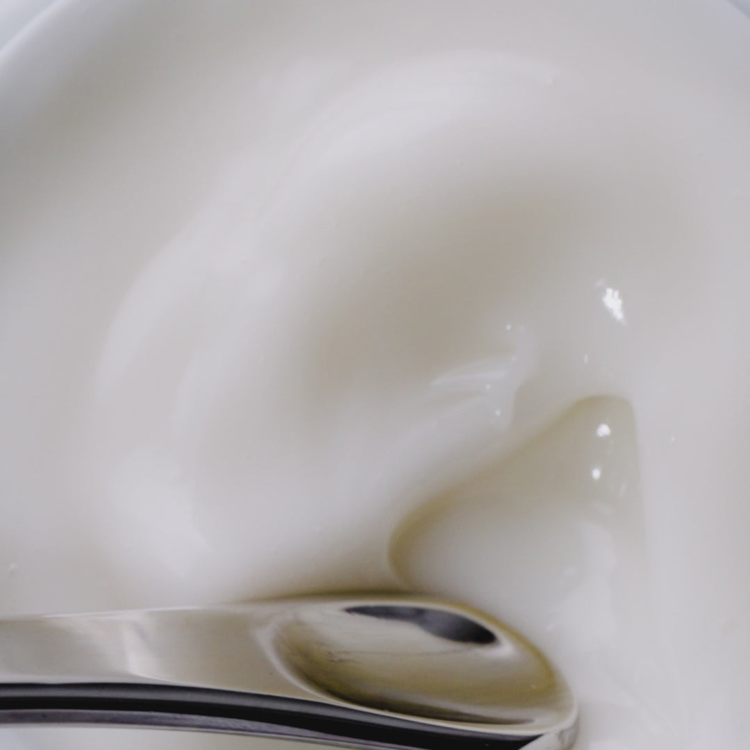 A video of the dewy gel cream being stirred with a silver spatula. 